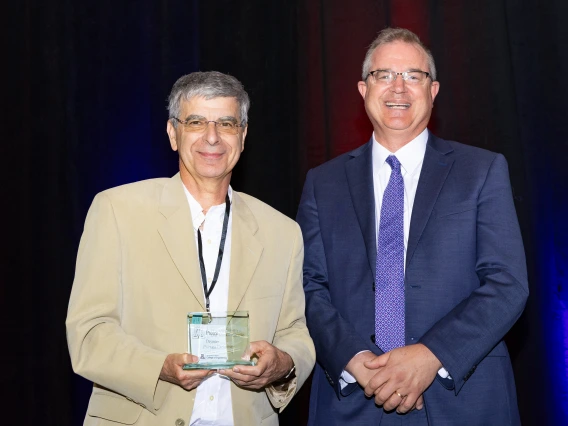 Deymier and Hahn pose with a glass award.