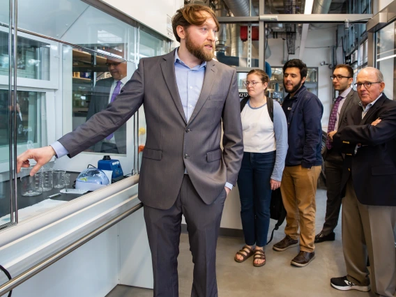 Biomedical engineering assistant professor Philipp Gutruf shows a group some of the lab's equipment.