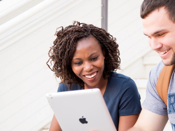 two students look at a laptop