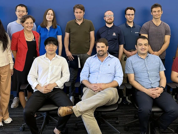 A group of instructors poses indoors, with one row sitting and one standing