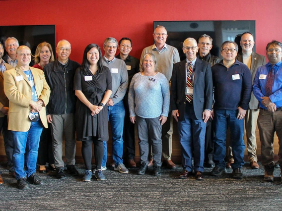 the large group of awardees stands together indoors