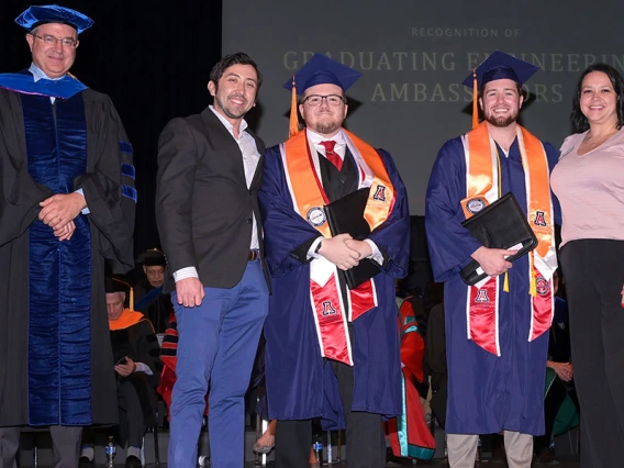 Five people stand on stage at the convocation ceremony