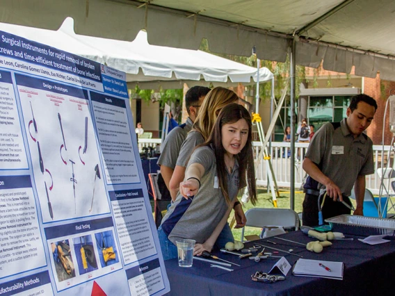 A group of students at an outdoor expo table