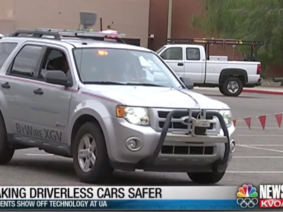 Screencap of a newscast with a car driving across the frame and a lower-third caption that reads, "Making Driverless Cars Safer: Students Show Off Technology at UA"