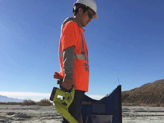 Taehee Lee applies a blower to the desert dirt.