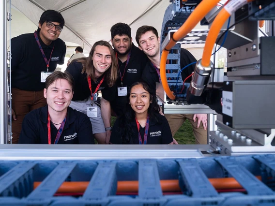 6 students pose with a manufacturing device