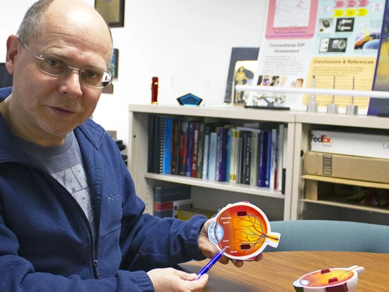 Wolfgang Fink holds a schematic of an eyeball