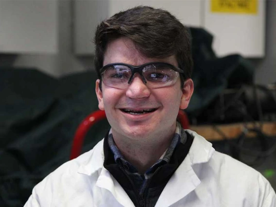 Gabriel Schirn wearing protective eye gear and a lab coat