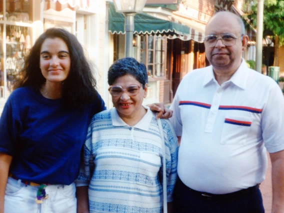 Three people -- an adult daughter and her parents -- smile for a photo.