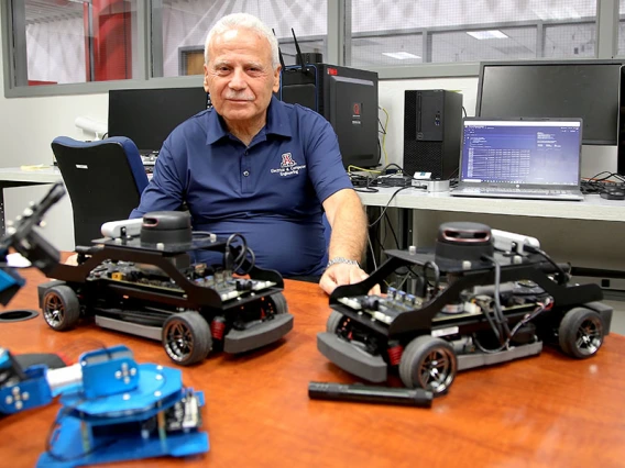 Salim Hariri in his lab with autonomous vehicles