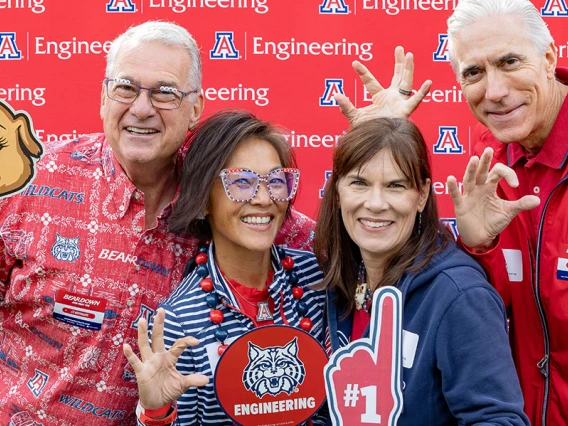 four people in front of a photo backdrop