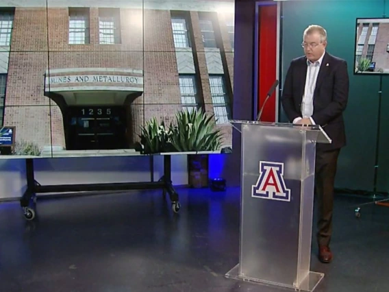 Screenshot of a video in which David W. Hahn stands at a podium speaking, with an image of the Old Engineering building behind him.