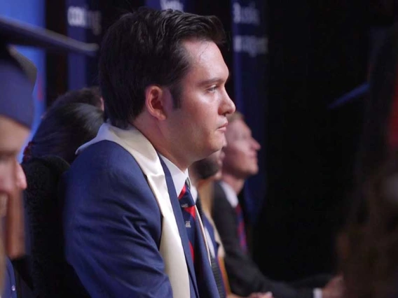 Profile photo of Jeffrey Bristol, sitting in a blue suit and graduation sash, looking straight ahead.