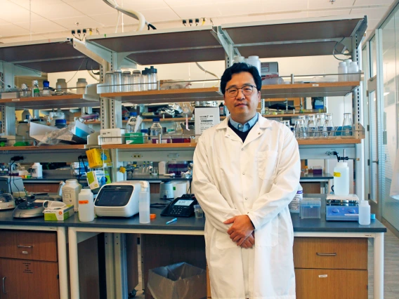 Minkyu Kim in a white lab coat in his laboratory