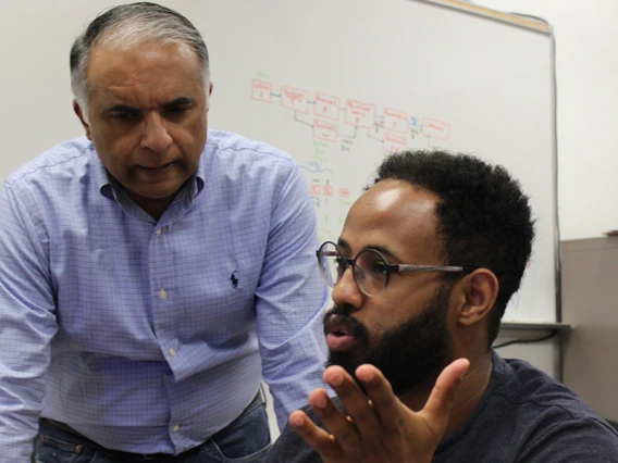 Two people speak in a classroom