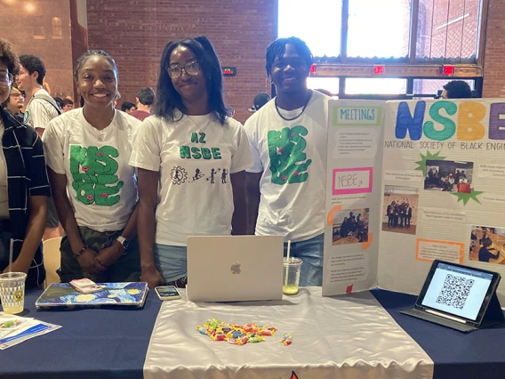 Four students pose for a photo at a student event.