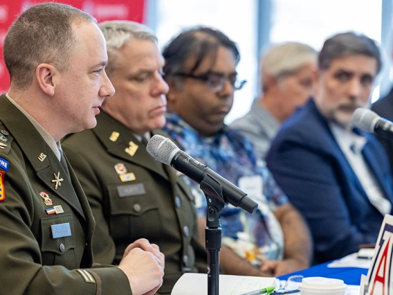 conference panelists sit at a table