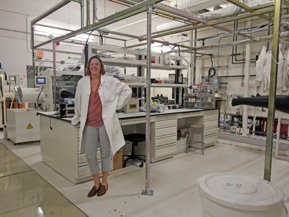 Erin Ratcliff in her lab, wearing a lab coat.