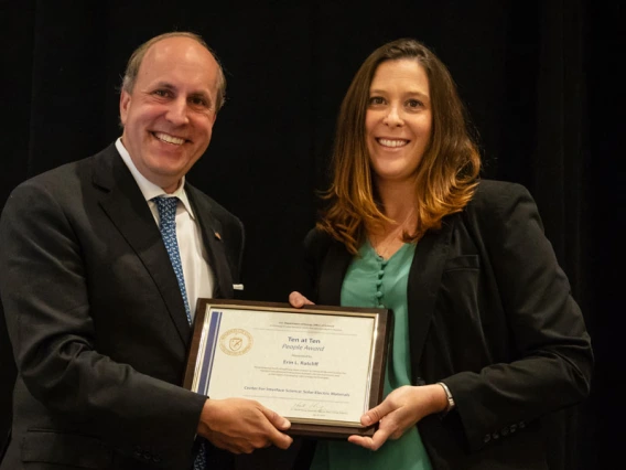 Erin Ratcliff receives a framed certificate from Department of Energy Under Secretary for Science Paul Dabber