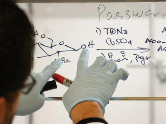 A man writing in marker on a window.