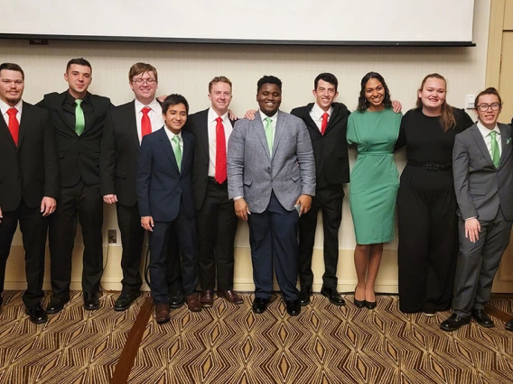 A row of about 12 people posing for a photo.