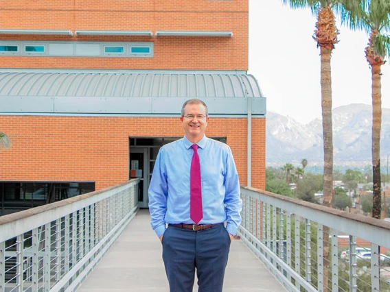 David Hahn stands on the exterior footbridge between the two sections of the Aerospace & Mechanical Engineering Building.