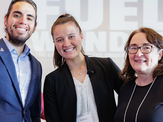 Three people pose indoors