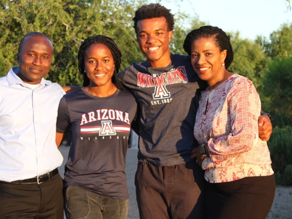 A family of four poses outdoors