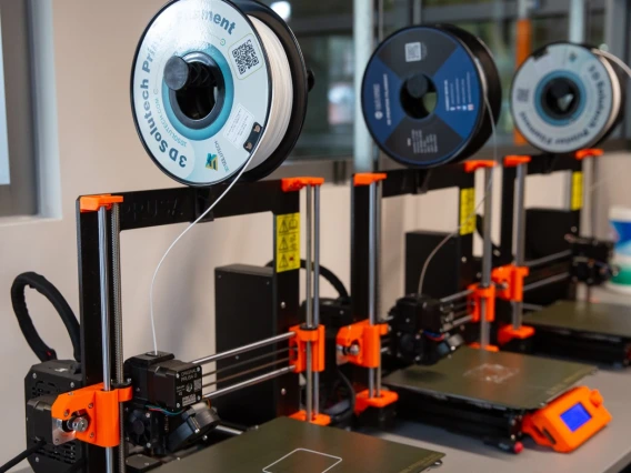 three 3D printers in a lab