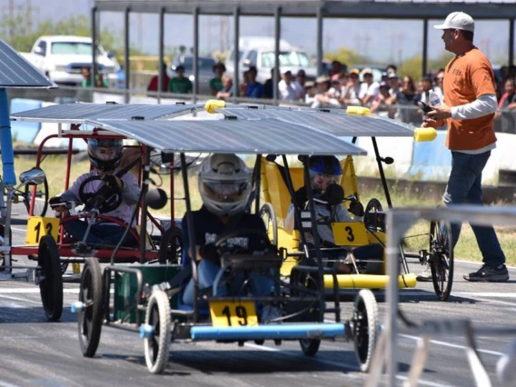 Students in solar-powered go-karts get ready at the starting line of a race.