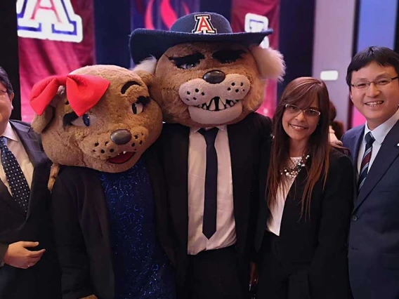 Two men and a woman pose for a photo with Wilma and Wilbur Wildcat