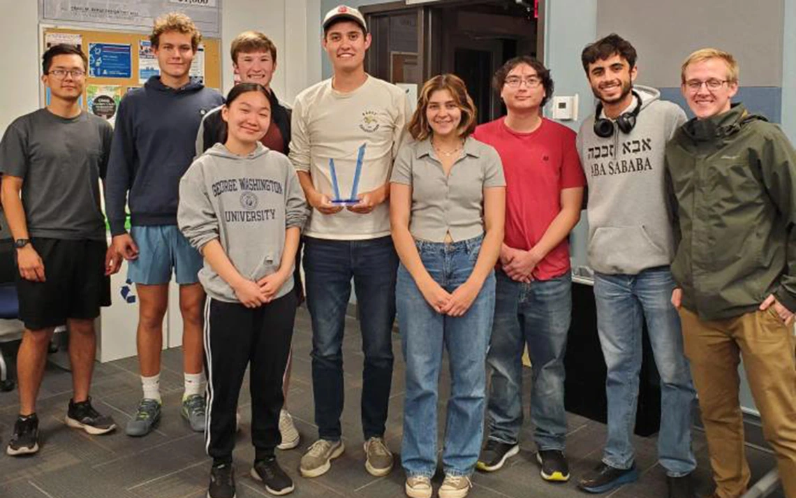 Students in different colored shirts pose for a photo.