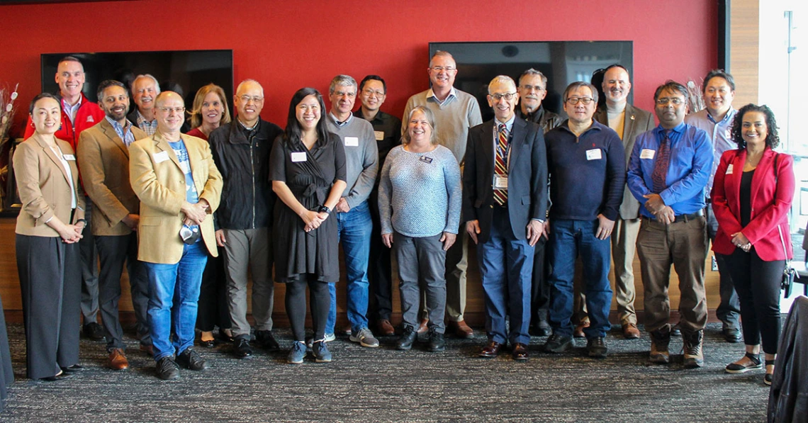 the large group of awardees stands together indoors