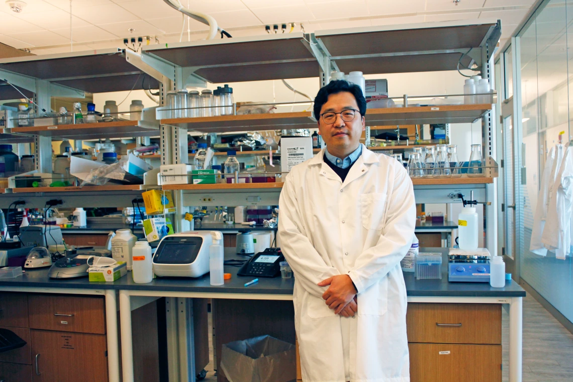 Minkyu Kim in a white lab coat in his laboratory