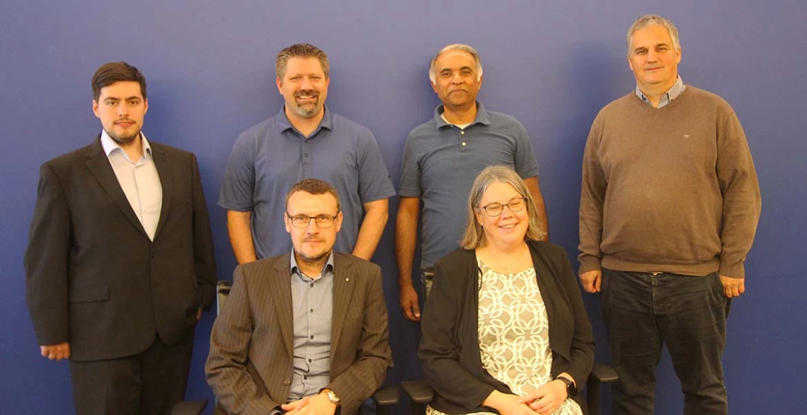 a group of 6 people poses indoors