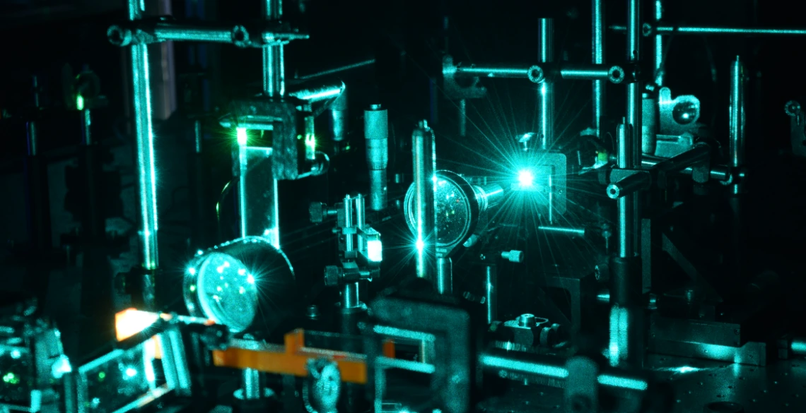 A setup in a materials science and engineering laboratory, lit with dim blue light.