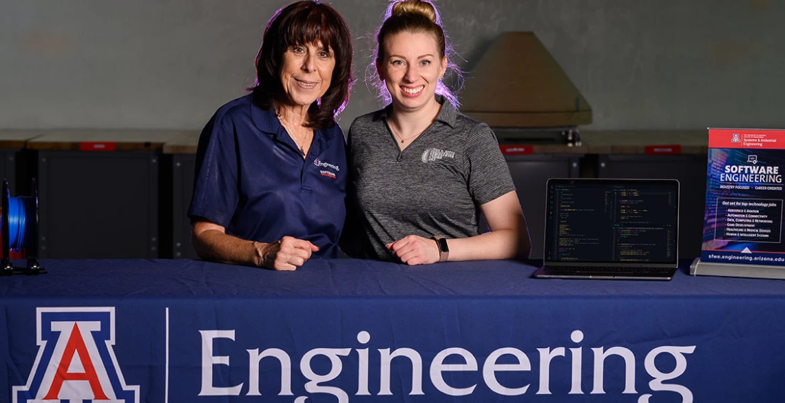 Sharon ONeal and Juliana Lincoln stand at a table with a laptop