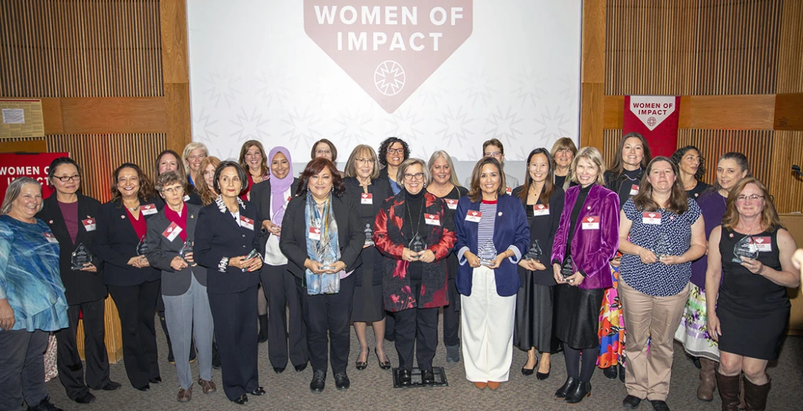 all awardees pose under a banner