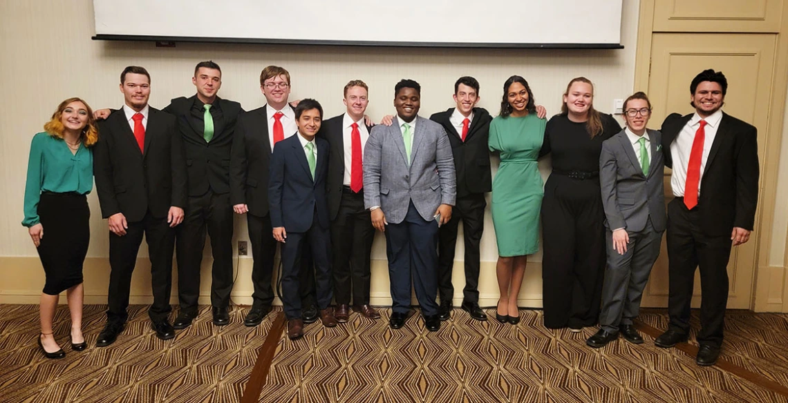 A row of about 12 people posing for a photo.