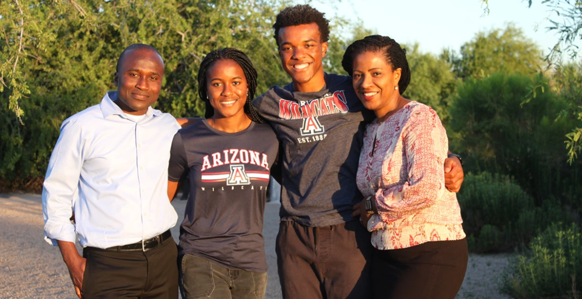 A family of four poses outdoors