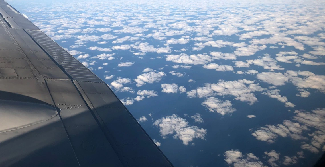 a view of clouds and an airplane wing