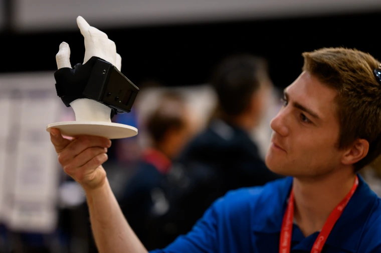 A judge examines a brace prototype applied to an artificial hand