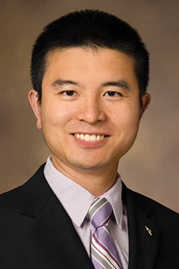 A man with brown hair smiles at the camera.