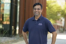 A man in a blue polo takes a photo.