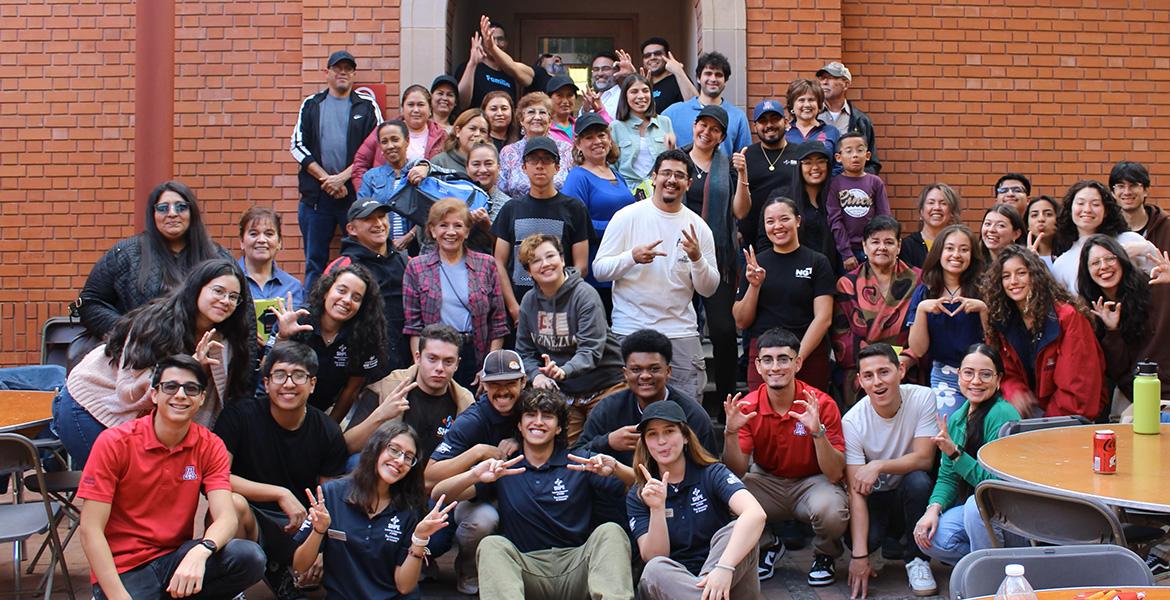 Students and event participants pose for a photo in the Old Engineering Building courtyard.
