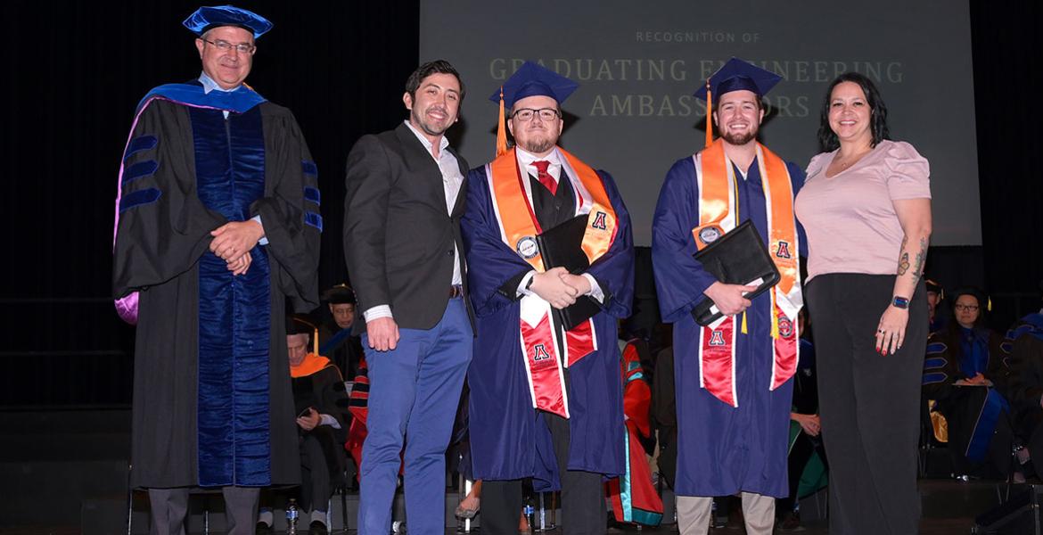 Five people stand on stage at the convocation ceremony