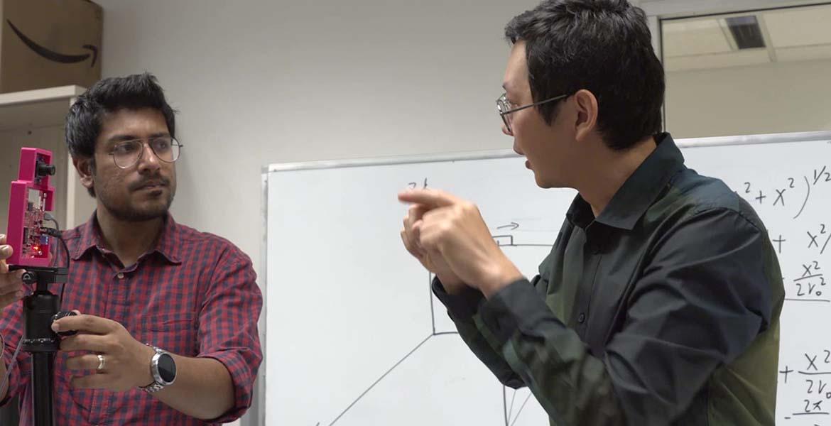 two faculty members work with radar equipment in a classroom