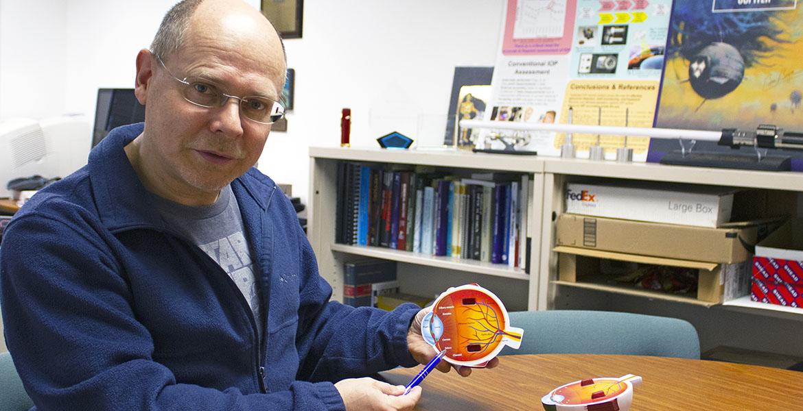 Wolfgang Fink holds a schematic of an eyeball