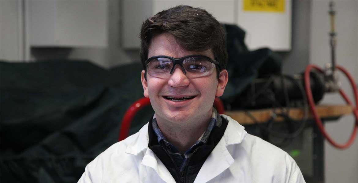 Gabriel Schirn wearing protective eye gear and a lab coat