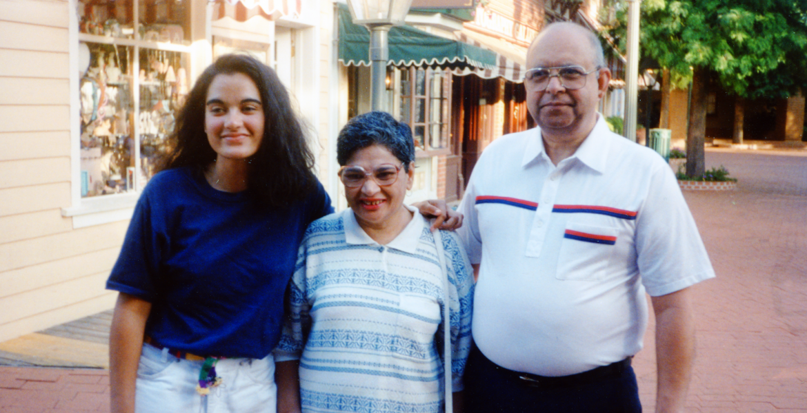 Three people -- an adult daughter and her parents -- smile for a photo.